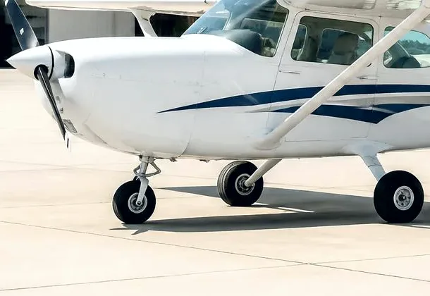 A Cessna 172 on the apron in front of a hangar